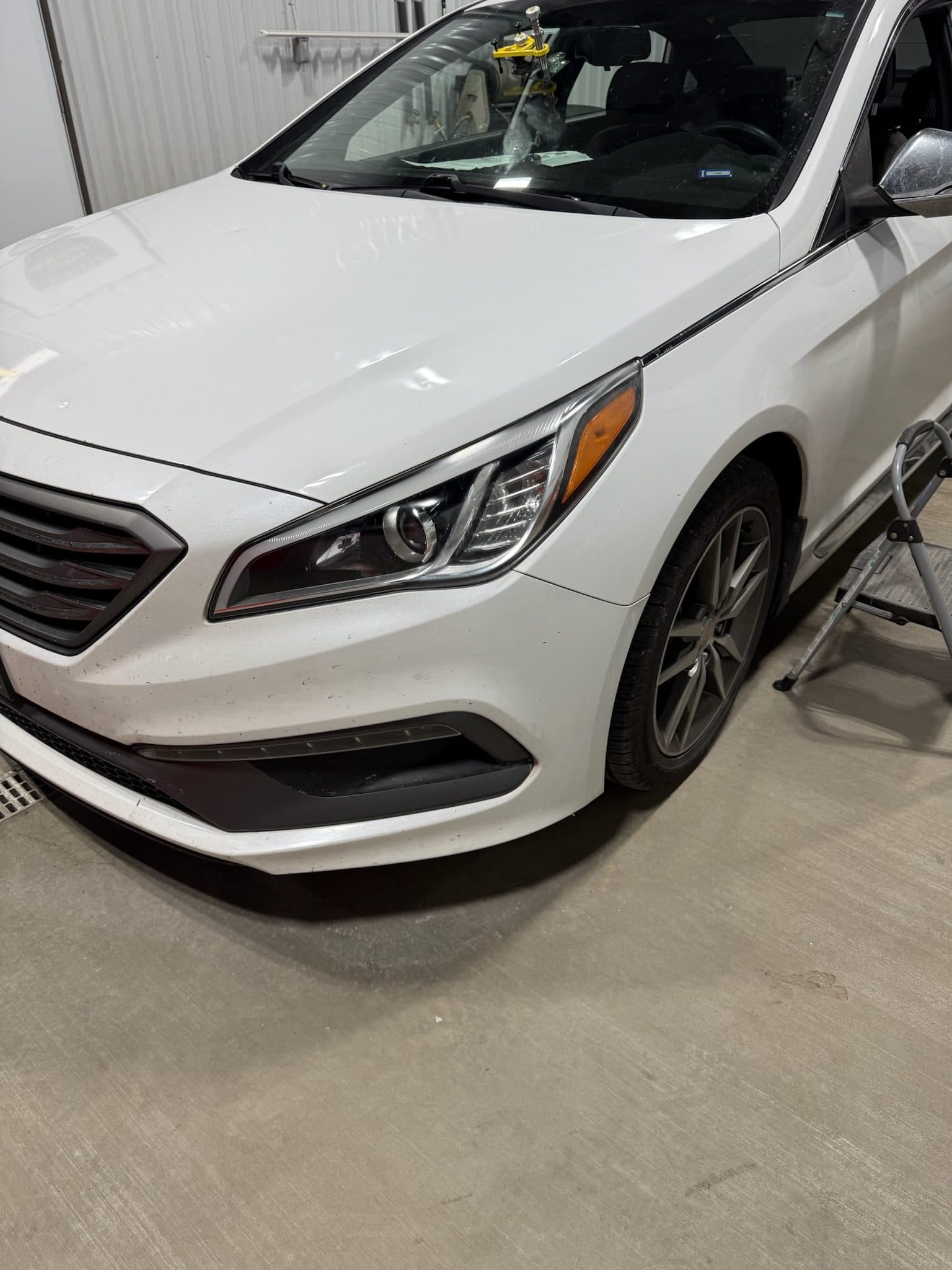 Restored headlight on a white sedan