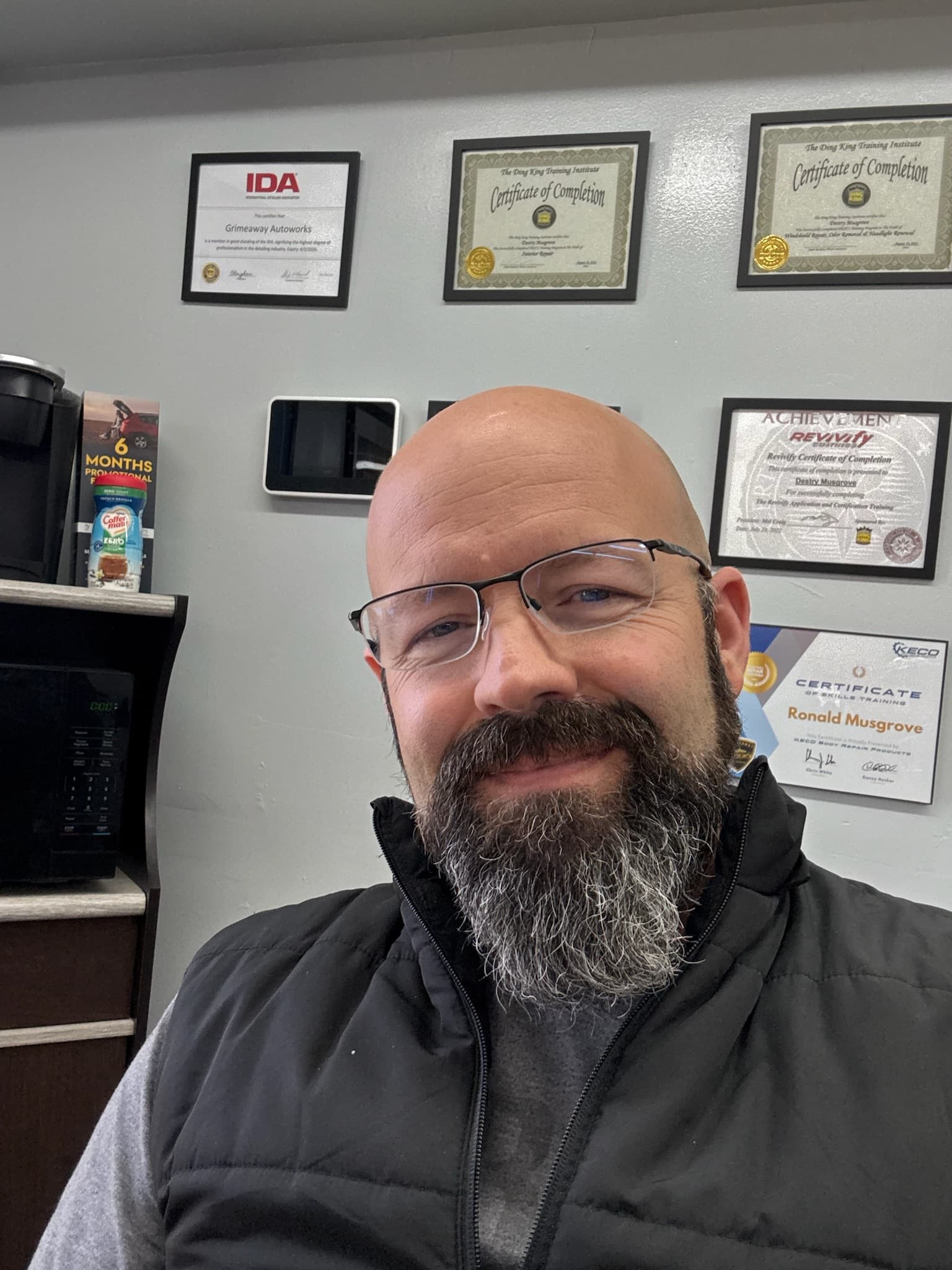 Destry Musgrove in front of his framed certifications