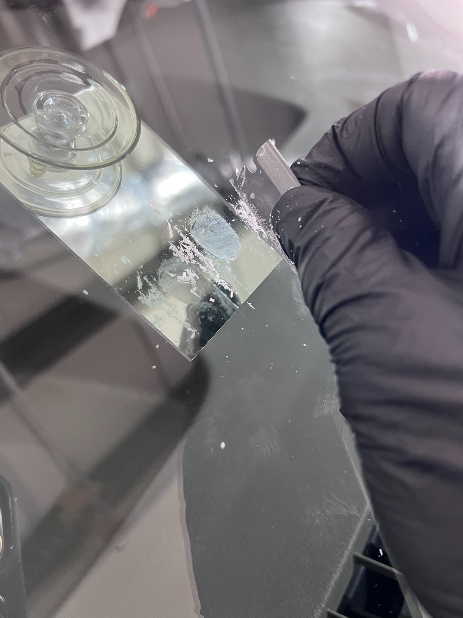 Resin being worked into a chipped windshield