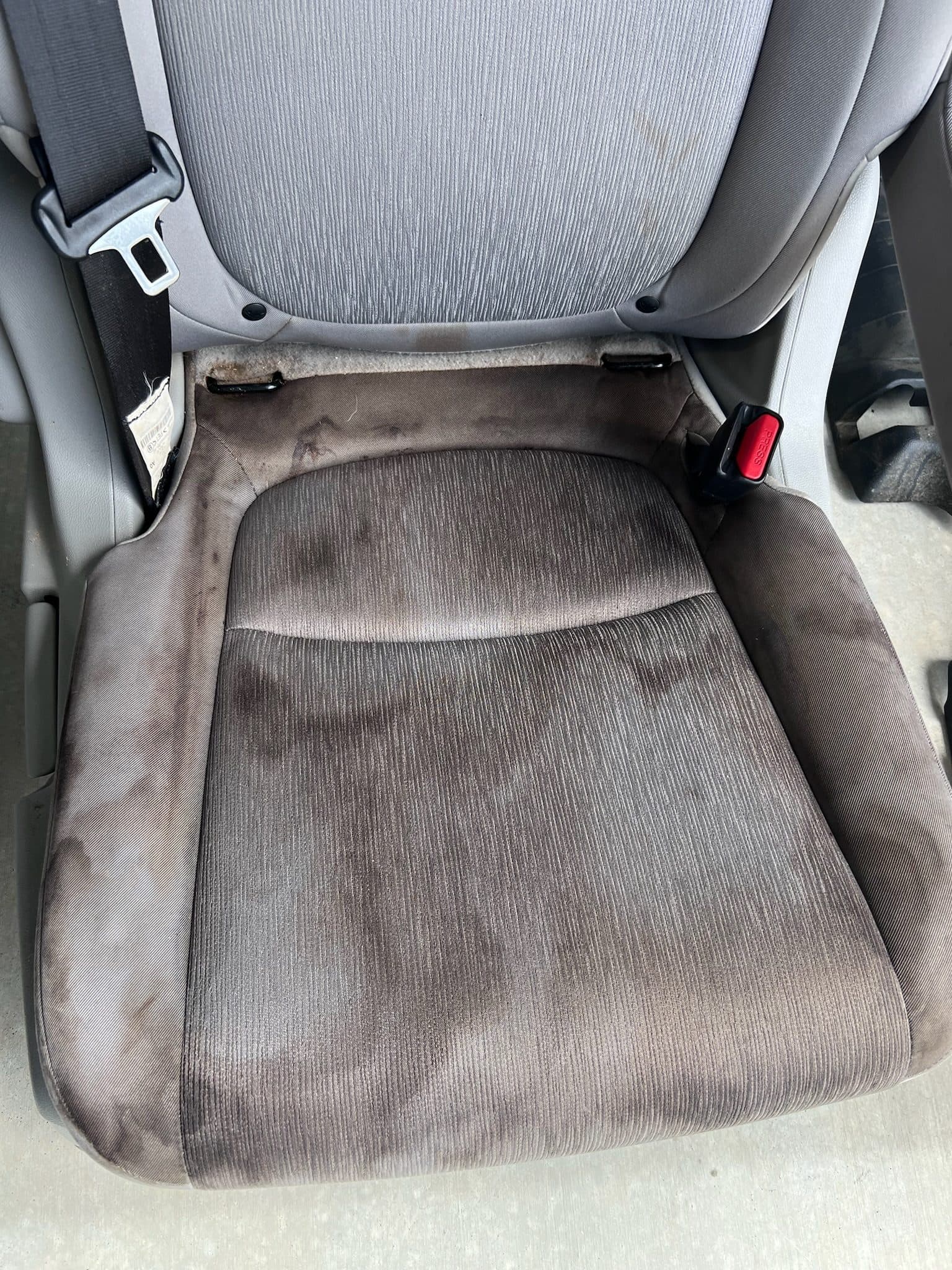 Heavily soiled cloth seat before restoration