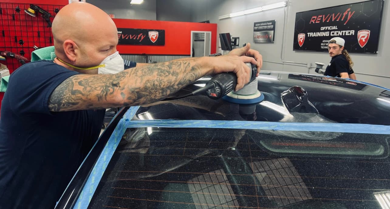 Paint correction in progress on a taped-off panel